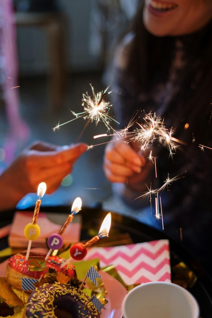 Joyful birthday scene featuring sparklers and decorated doughnuts, capturing a celebratory moment.